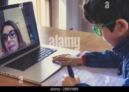 kid using a laptop for his homework. E-learning concept. Boy employing on line education during self isolation time. Stock Photo