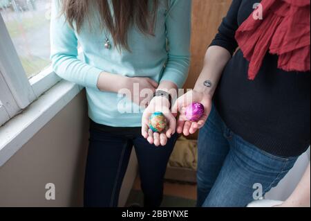 Two hard boiled, decorated Easter eggs on display in a family environment.