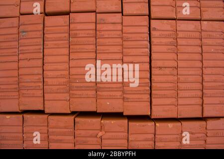 A stack of new red clay bricks for new construction Stock Photo
