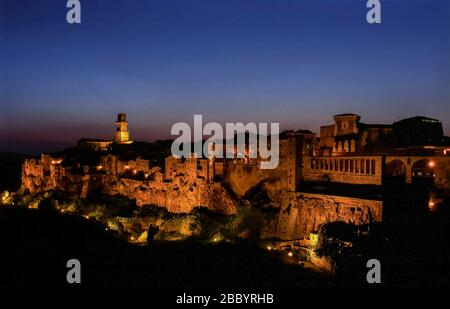 Superb view of the village built on the tuff of Pitigliano, Grosseto, Tuscany, Italy, illuminated by the evening light of the blue hour after sunset Stock Photo