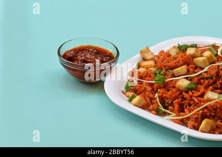 .Schezwan paneer fried rice with schezwan sauce,Chinese fried rice with paneer,garnished with spring onion and cabbage Stock Photo