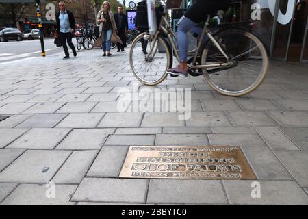 STOCKHOLM, SWEDEN - AUGUST 22, 2018: People walk by memorial plaque at the location of mysterious assassination of Olof Palme, Prime Minister of Swede Stock Photo