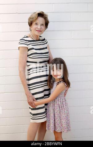 Five year old girl standing next to her great grandmother Stock Photo