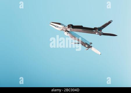 The multitool multi-function tool hovers on a blue background. The concept of an expanded multi-tool with free space. Stock Photo