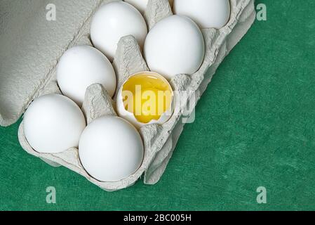Paper Egg Tray with white eggs. chicken white eggs close up. broken chicken white egg. eggs on green background Stock Photo