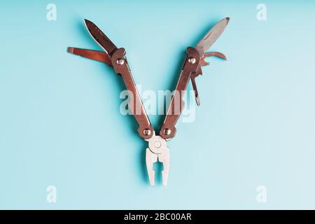 The multitool multi-function tool hovers on a blue background. The concept of an expanded multi-tool with free space. Stock Photo