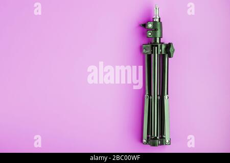 Tripod on pink background for photo-video camera and flash. Free space Stock Photo