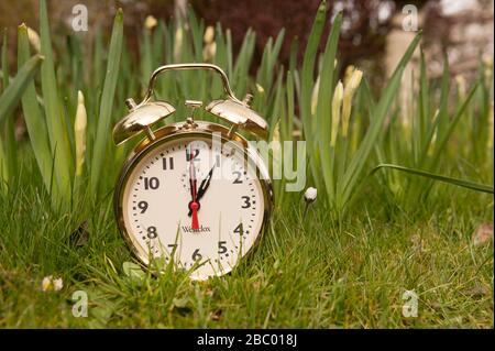 Clocks spring forward in March losing an hours sleep gaining longer evening daylight, British summertime, golden clock Stock Photo