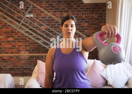 Plus size female vlogger self isolating exercising at home Stock Photo
