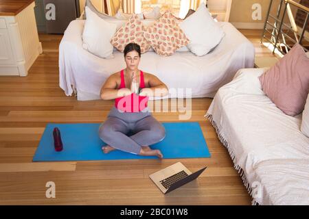 Plus size female vlogger self isolating practicing yoga at home Stock Photo