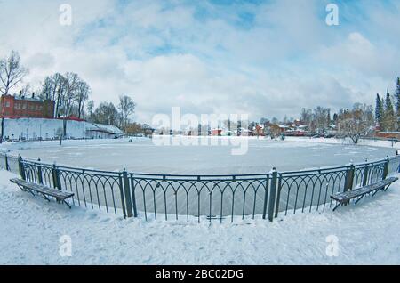 Winter snowy day in Russia - Kelarskiy Pond in small city Sergiev Posad, blue sky, icy water, fisheye, perspective distortion, wide angle.