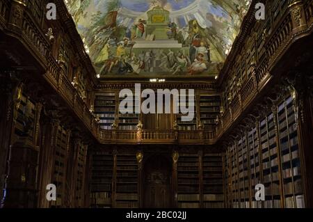 Prague, Czech Republic - 30 December 2019: old library with a lot of books inside decorated shelves and a frescoed ceiling (Philosophical hall, Straho Stock Photo