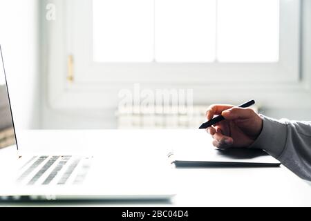 Young man designer using a stylus, graphics table and computer. Stock Photo
