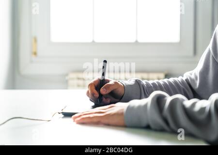 Young man designer working using graphics tablet at home office Stock Photo
