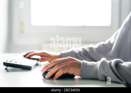 Young man working with computer. Using keyboard and mouse. Stock Photo