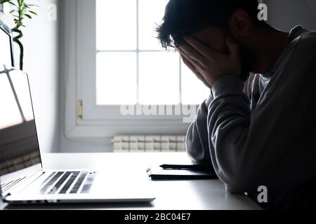 Young man tired of working from home with the computer Stock Photo
