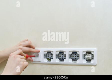 Electrician install outlets on beige wall with eu standards Stock Photo