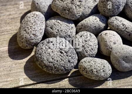 volcanic lava pebbles background, porous lava stone textured surface Stock Photo