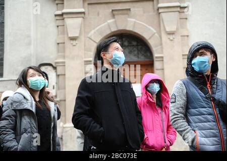 A group of tourists from Malaysia with mouthguards against the corona virus is standing in front of the church 'Alter Peter' in downtown Munich. [automated translation] Stock Photo