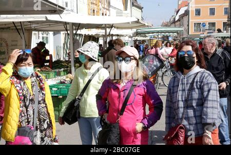 Tourists from the Far East wear breathing masks at the weekly market in downtown Freising in the face of the corona crisis. [automated translation] Stock Photo