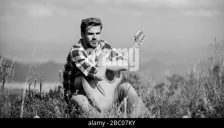 Pleasant time alone. Musician looking for inspiration. Dreamy wanderer. Peaceful mood. Guy with guitar contemplate nature. Wanderlust concept. Inspiring nature. Summer vacation highlands nature. Stock Photo