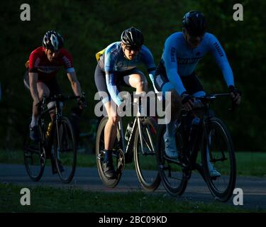 Cyclists caught in the sunlight whilst competing in Criterium Race at Crystal Palace Park. Stock Photo