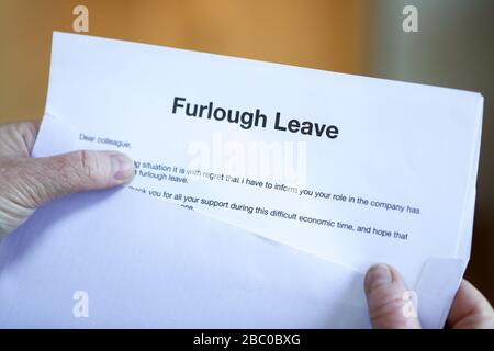 Woman with furlough Leave letter. Furloughed workers in the UK are to receive 80% of their pay from the UK Government during the coronavirus pandemic. Stock Photo