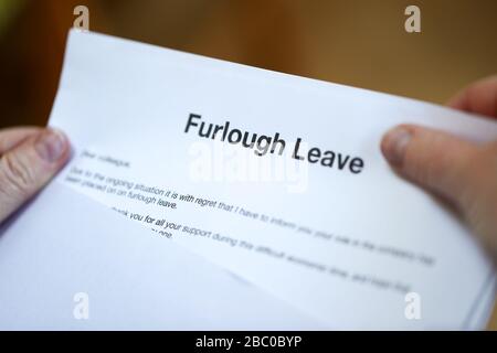 Woman with furlough Leave letter. Furloughed workers in the UK are to receive 80% of their pay from the UK Government during the coronavirus pandemic. Stock Photo