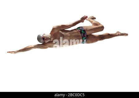 Professional caucasian male swimmer with hat and goggles practicing and training isolated on white studio background. Grace of motion and action. Healthy lifestyle, sport and movement concept. Stock Photo