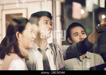 three asian small company businesspeople young entrepreneurs meeing discussing in office using sticky notes Stock Photo