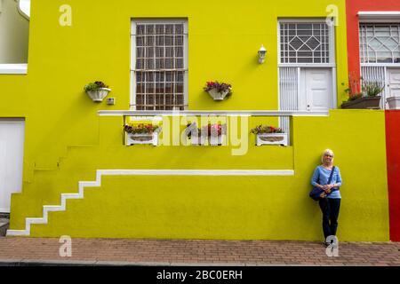 South Africa, Cape Town, Schotsche Knoof, Bo Kaap, Chiappini St, tourist at green painted front wall of colourfully painted restored home Stock Photo