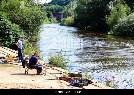 Two men fishing on the River Severn downstream from the famous Iron Bridge in Shropshire, UK Stock Photo