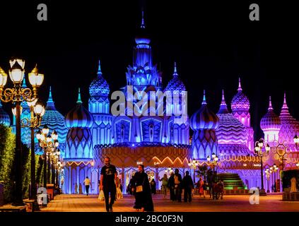 Night time shot of people leaving Global Village, Dubai, UAE. Global Village combines cultures of 90 countries across the world in one place. Stock Photo