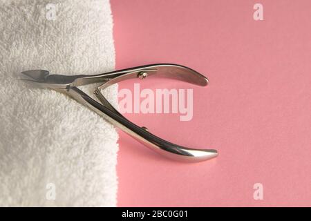 Cuticle cutters stuck to white towels on a pink table Stock Photo