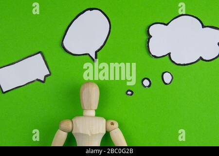 Handcrafted wooden man figure mannequin model dummy doll with blank speech bubble on green background, objects, nobody Stock Photo