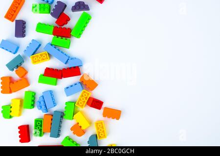Different colored building blocks scattered across an empty white isolated background Stock Photo