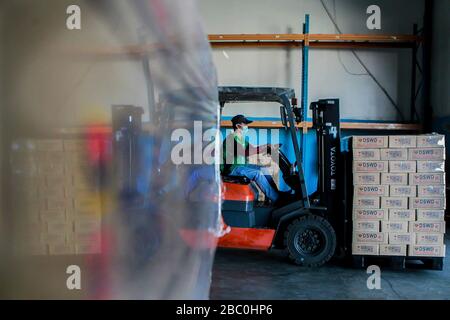 (Pasay City, Pasay City. 2nd Apr, 2020. A volunteer wearing a face mask uses a forklift to load relief goods onto trucks at a government warehouse in Pasay City, the Philippines on April 2, 2020. The Philippines on Thursday required all those living in areas under enhanced community quarantine to wear face masks or other forms of protective equipment when they leave their homes to slow the spread of COVID-19. Credit: Xinhua/Alamy Live News Stock Photo