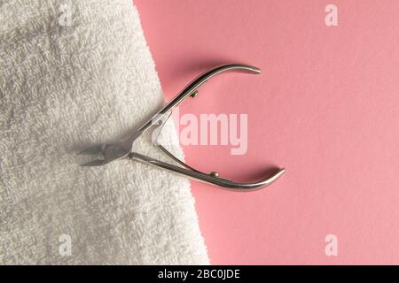 Cuticle cutters stuck to white towels on a pink table Stock Photo