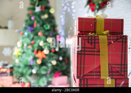 present boxes at christmas tree. happy new year. celebrate xmas at home. winter holiday shopping. shopping sales. gift delivery. Red, pink, silver Stock Photo