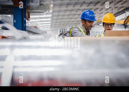 Managers using laptop in factory Stock Photo
