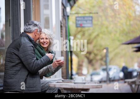 Senior couple drinking coffee at sidewalk cafe Stock Photo