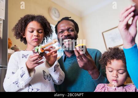 Portrait happy father and daughters eating cupcakes Stock Photo