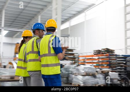 Supervisor and workers walking and talking in warehouse Stock Photo