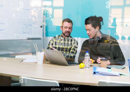 Businessmen using laptop in conference room meeting Stock Photo