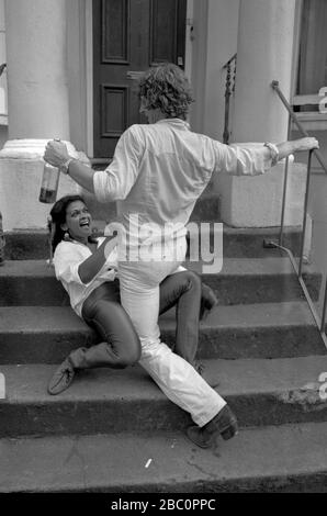 Couple dancing, both are drunk 1981 during the Notting Hill Carnival. 1980s He is holding a bottle of alcohol. UK HOMER SYKES Stock Photo
