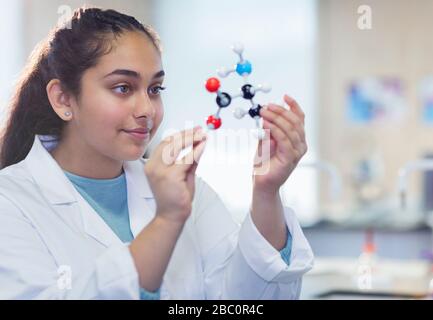 Curious girl student examining molecular structure in laboratory classroom Stock Photo