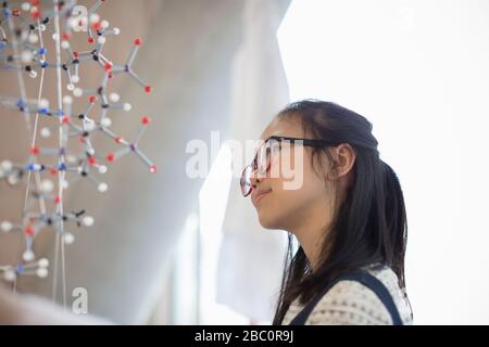 Pensive, curious girl student examining molecular structure Stock Photo