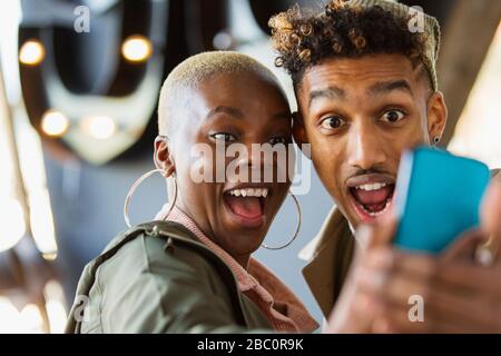 Playful young couple taking selfie with camera phone Stock Photo