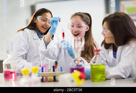 Curious girl students conducting scientific experiment in laboratory classroom Stock Photo
