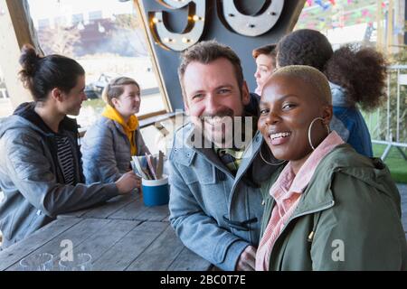 Portrait smiling couple dining with friends at restaurant outdoor patio Stock Photo